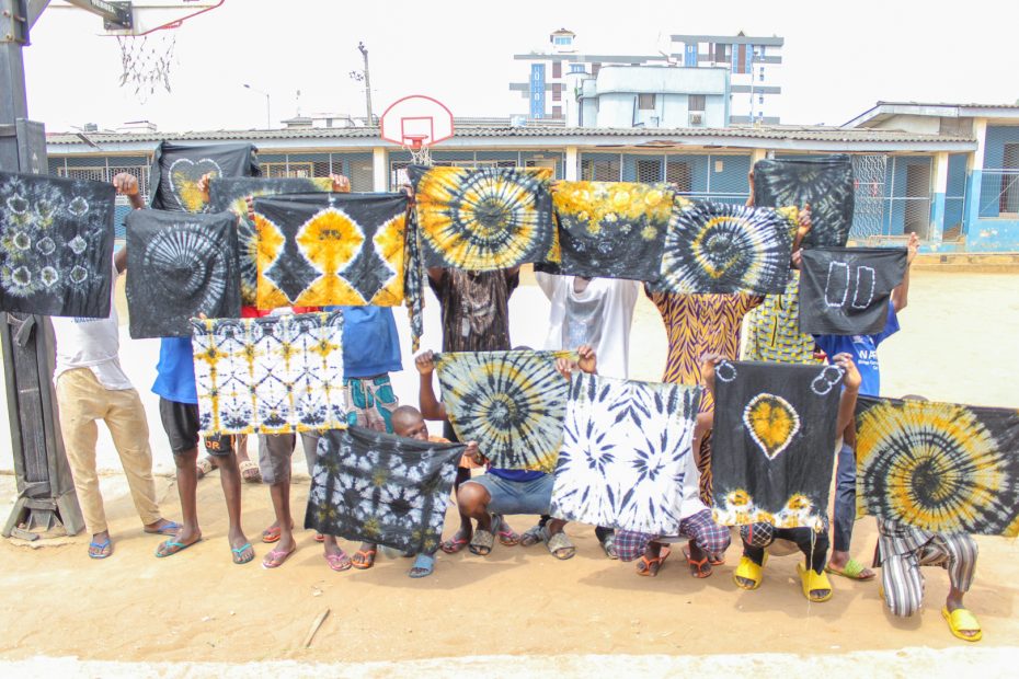 boys from correctional center oregun holding adire clothes